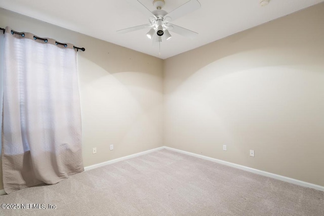 spare room featuring a ceiling fan, carpet, and baseboards