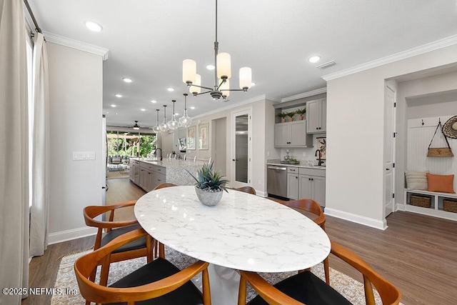 dining room with dark wood-type flooring and crown molding