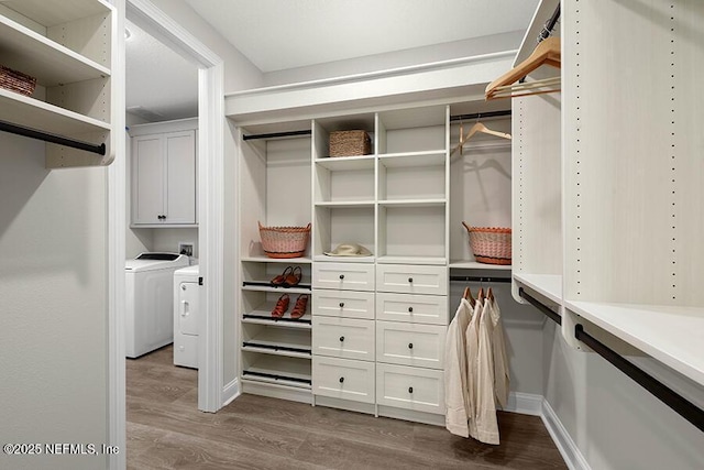 spacious closet featuring washing machine and dryer and dark wood-style flooring