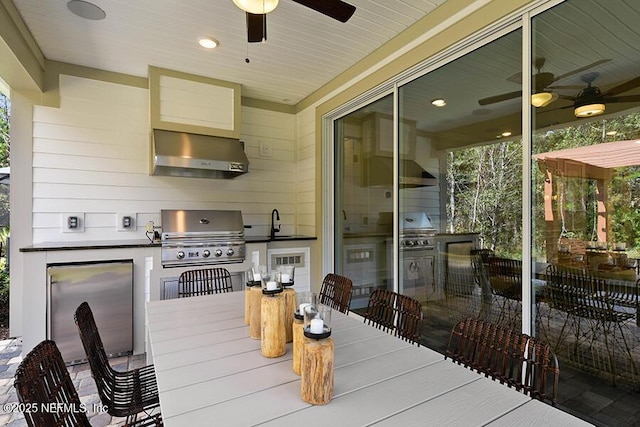 view of patio featuring outdoor dining area, an outdoor kitchen, ceiling fan, and grilling area