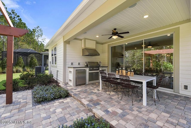 view of patio featuring outdoor dining space, cooling unit, an outdoor kitchen, ceiling fan, and grilling area