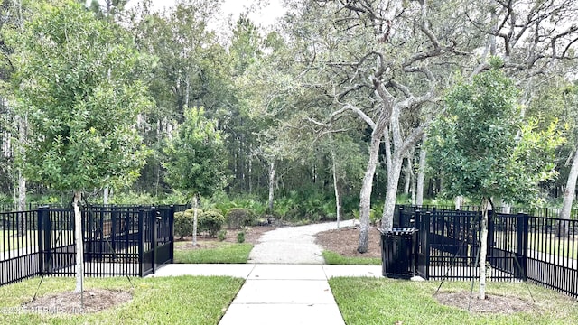 view of property's community featuring a yard and fence