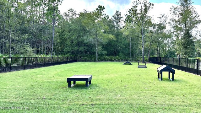 view of community with a yard and fence