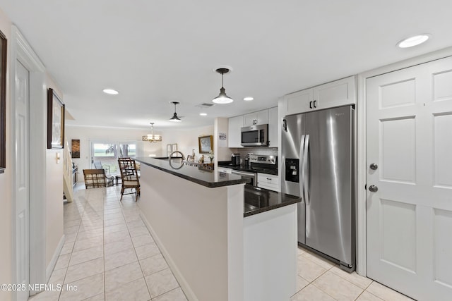 kitchen with light tile patterned floors, stainless steel appliances, dark countertops, and white cabinets