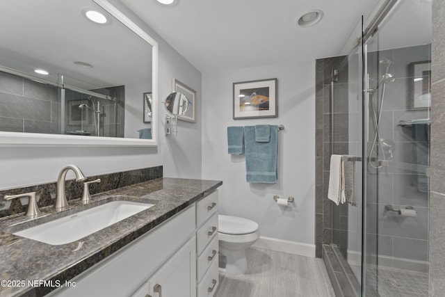 bathroom featuring recessed lighting, toilet, a stall shower, and vanity