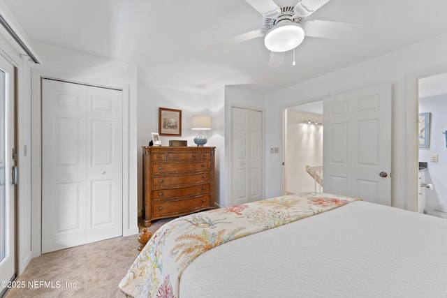 carpeted bedroom featuring two closets and a ceiling fan