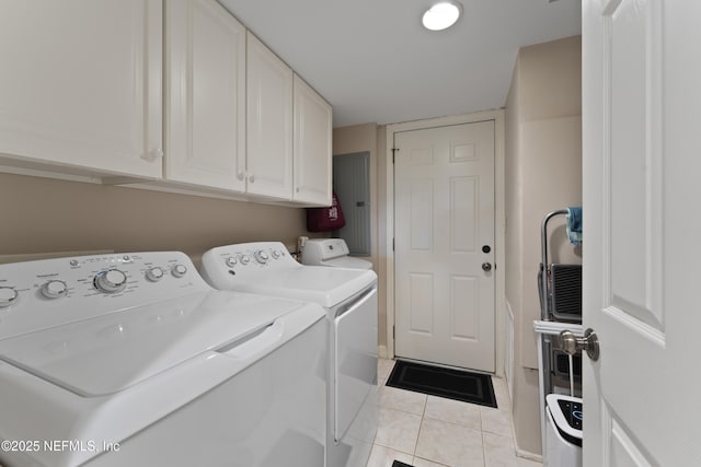 laundry area with cabinet space, light tile patterned floors, and washer and dryer