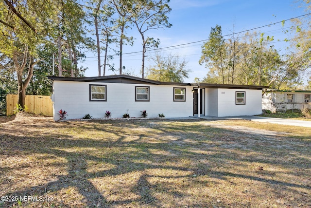 view of front of home featuring fence and a front lawn