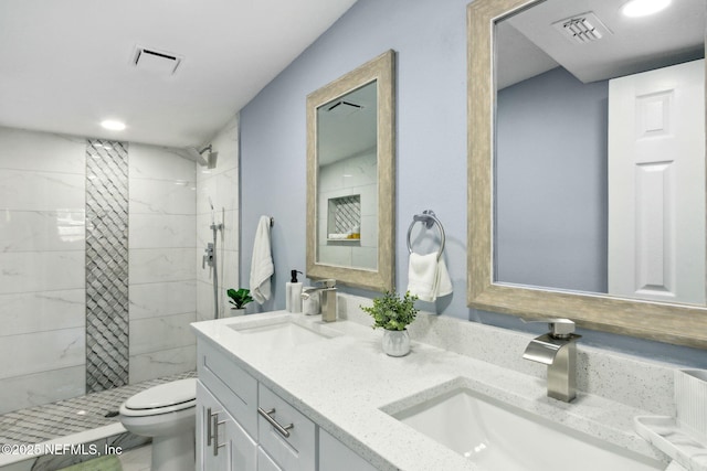 bathroom with toilet, a sink, and visible vents