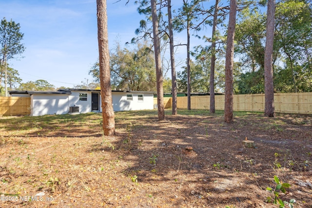 view of yard featuring fence and central air condition unit