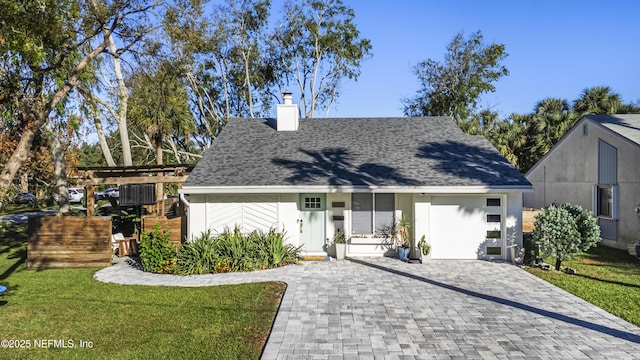 view of front of property featuring a shingled roof, a chimney, and a front lawn