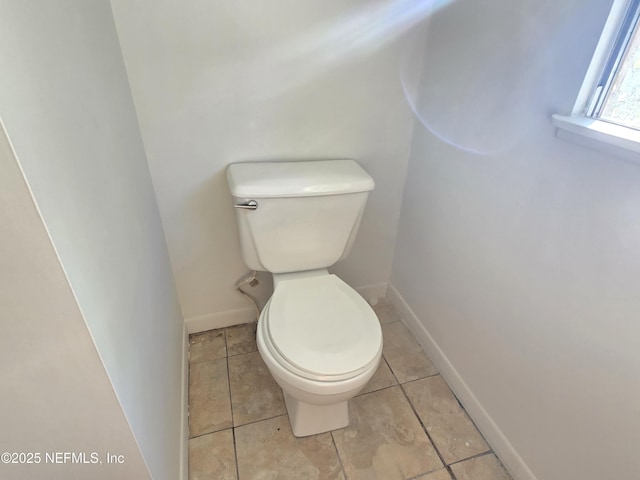 bathroom featuring toilet, baseboards, and tile patterned floors