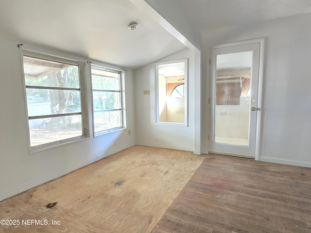 unfurnished room featuring lofted ceiling and wood finished floors