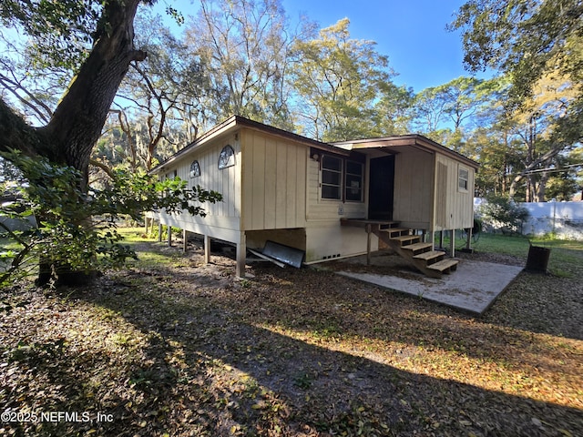 rear view of property with entry steps and fence