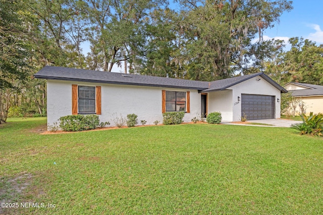 view of front facade featuring a garage, driveway, a front yard, and stucco siding