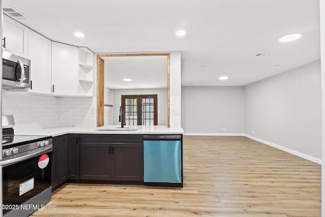 kitchen featuring open shelves, stainless steel appliances, visible vents, white cabinetry, and a sink