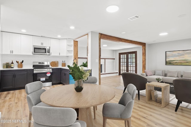 dining room featuring recessed lighting, french doors, visible vents, and light wood-style flooring