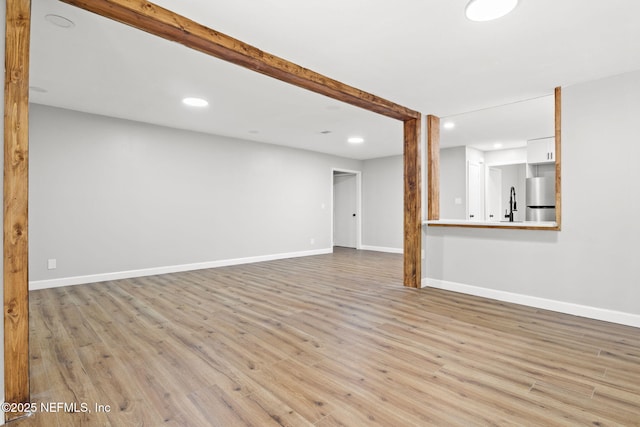 unfurnished living room featuring baseboards, wood finished floors, and recessed lighting