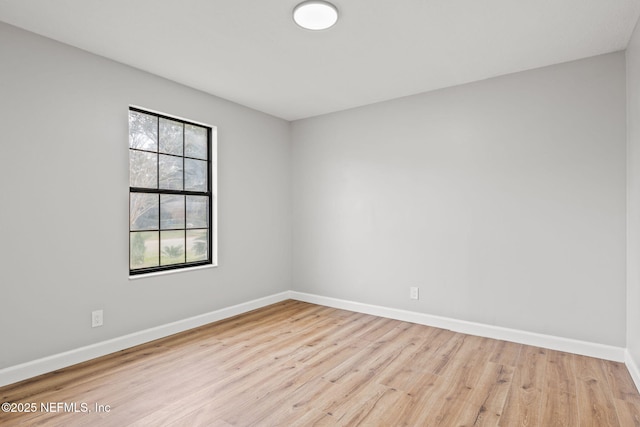 spare room featuring wood finished floors and baseboards