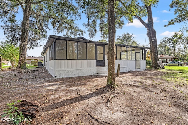 back of house with a sunroom and central AC unit