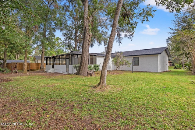 view of yard with a sunroom and fence