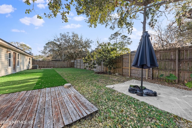 view of yard featuring a fenced backyard, central AC, and a patio