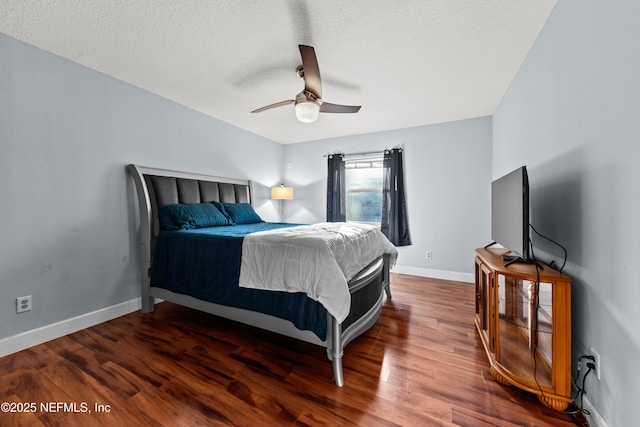 bedroom with ceiling fan, a textured ceiling, baseboards, and wood finished floors