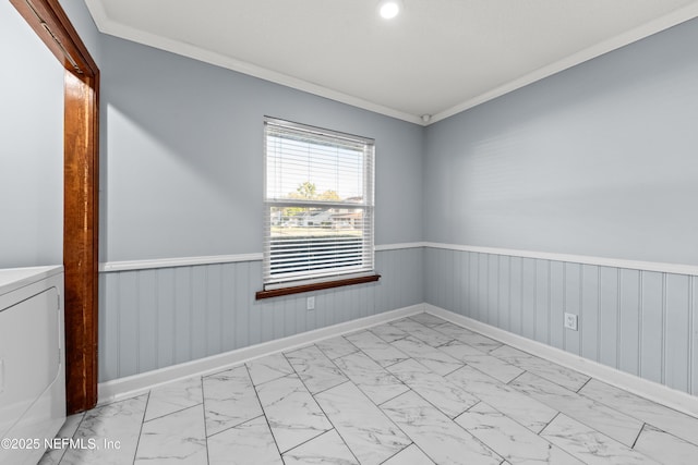 empty room with washer / dryer, marble finish floor, wainscoting, and ornamental molding