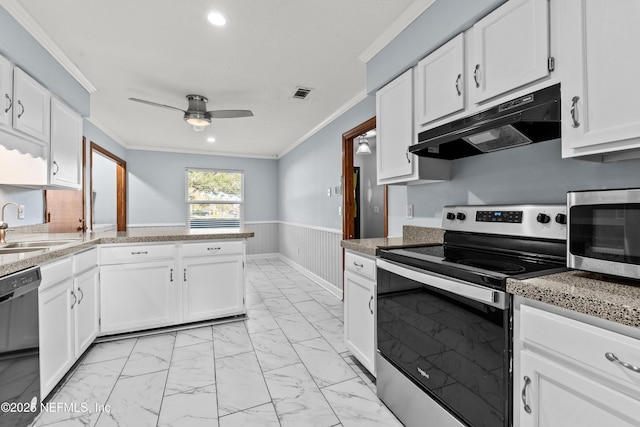 kitchen featuring marble finish floor, a wainscoted wall, crown molding, appliances with stainless steel finishes, and under cabinet range hood