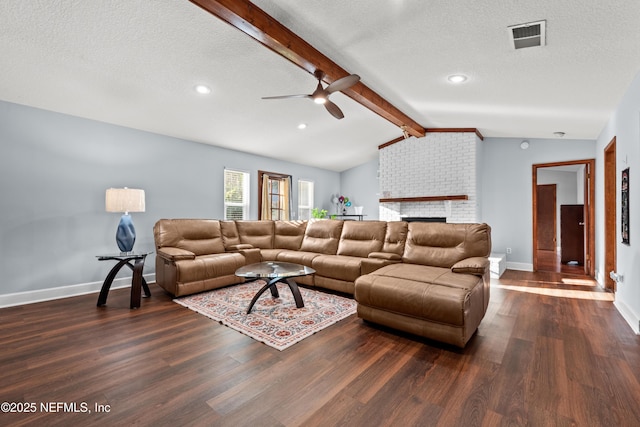 living area featuring vaulted ceiling with beams, a textured ceiling, dark wood finished floors, and visible vents