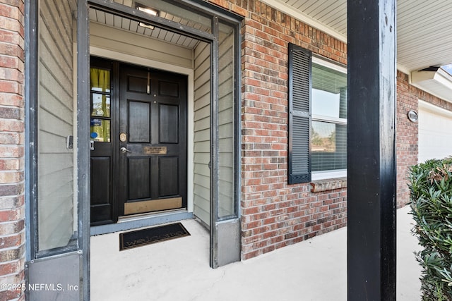 property entrance featuring covered porch and brick siding