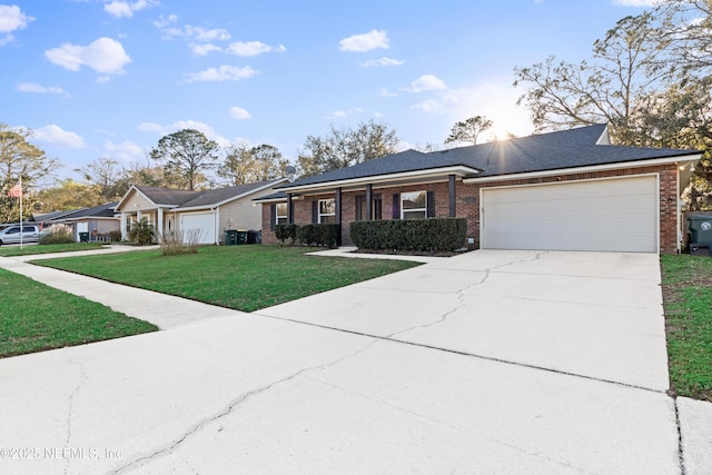 single story home featuring a garage, a front yard, concrete driveway, and brick siding