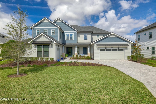 view of front facade with an attached garage, decorative driveway, and a front yard