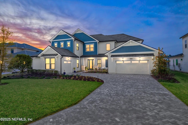 view of front of house featuring an attached garage, decorative driveway, and a front yard