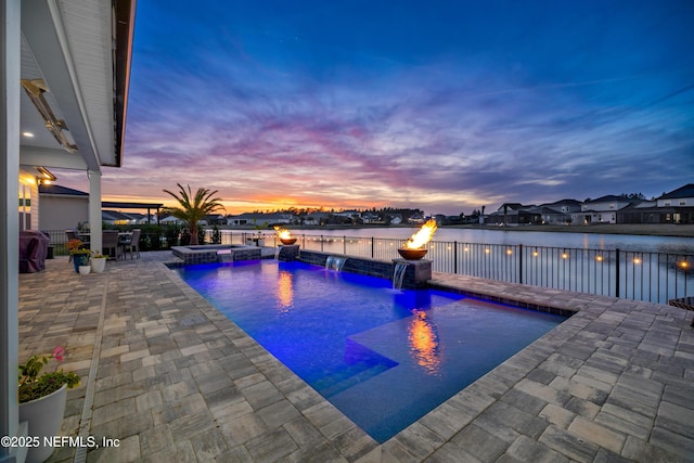 view of pool featuring a water view, a patio area, a pool with connected hot tub, and fence