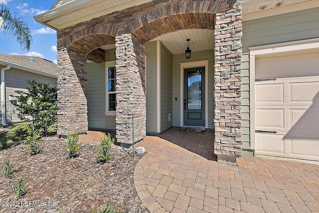 property entrance featuring an attached garage and a porch