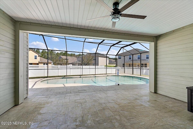 view of swimming pool featuring a lanai, a patio area, and a ceiling fan