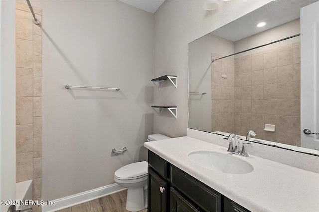 bathroom with vanity, wood finished floors, toilet, and baseboards