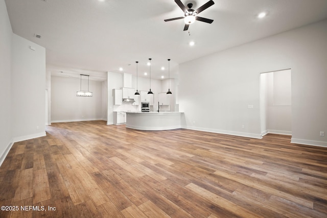 unfurnished living room with visible vents, baseboards, ceiling fan, light wood-type flooring, and recessed lighting