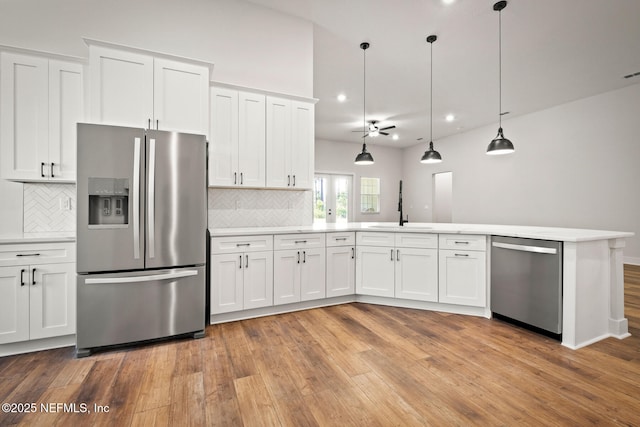 kitchen featuring light wood-style flooring, stainless steel appliances, a sink, white cabinets, and light countertops