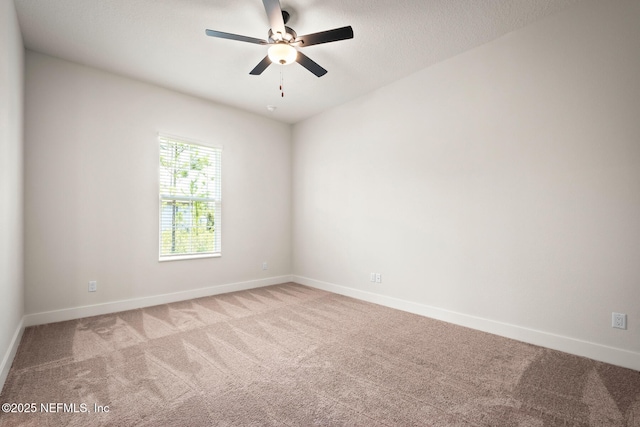 unfurnished room with light carpet, ceiling fan, a textured ceiling, and baseboards