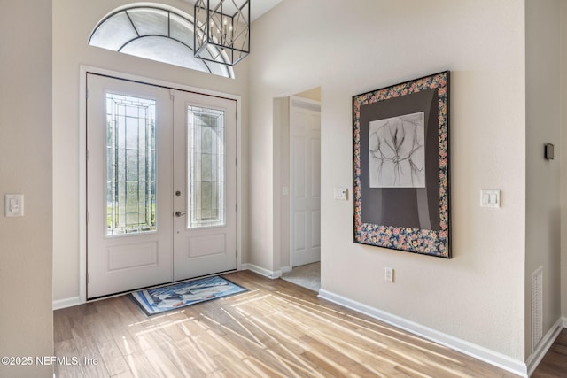 entryway with french doors, wood finished floors, and baseboards