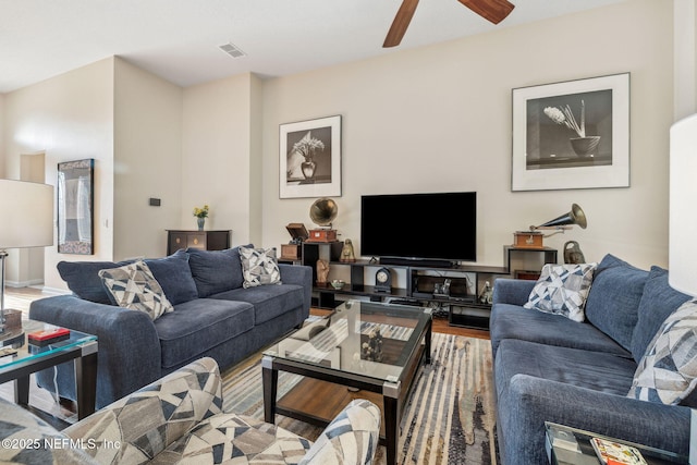 living area featuring visible vents, ceiling fan, and wood finished floors