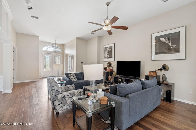 living area featuring hardwood / wood-style flooring, visible vents, baseboards, and a ceiling fan