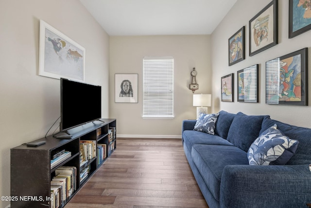 living area with baseboards and wood finished floors