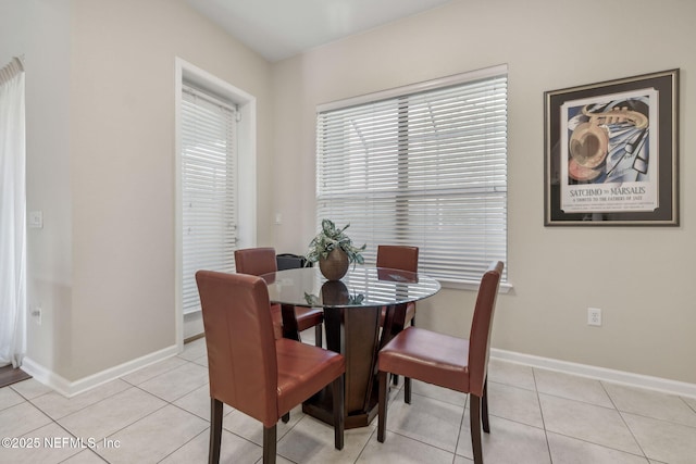 dining area featuring light tile patterned floors and baseboards