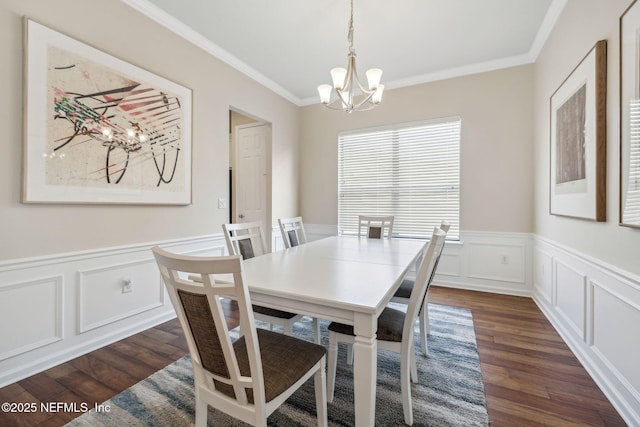 dining room with a wainscoted wall, ornamental molding, and dark wood-type flooring