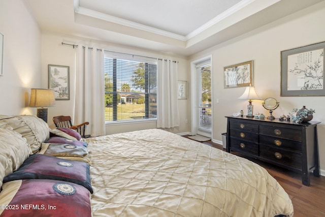 bedroom with wood finished floors, baseboards, access to outside, a raised ceiling, and crown molding