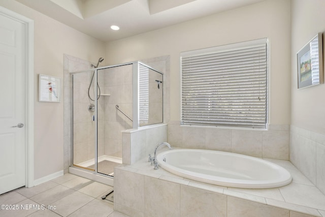 bathroom with a stall shower, tile patterned flooring, and a bath