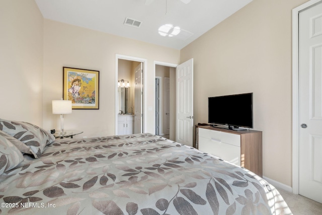 carpeted bedroom with ensuite bathroom and visible vents